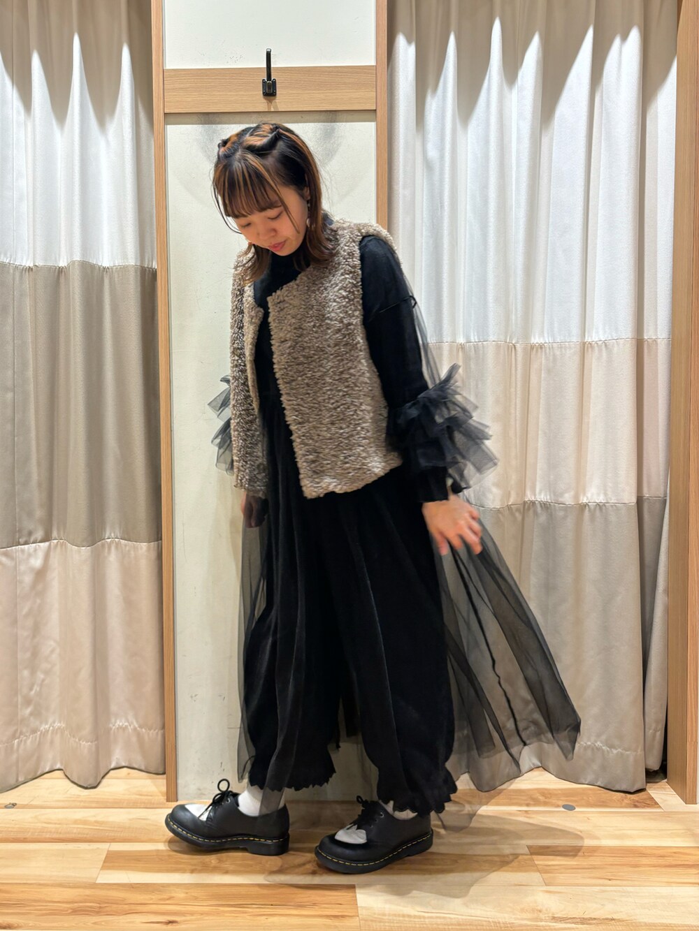 ブラウン系のベスト、ブラック系のワンピース、ブラック系のその他パンツを着用したレディースの秋コーディネートの2枚目の写真