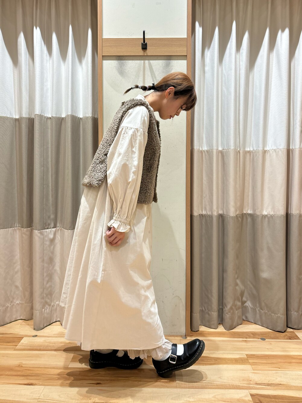 ホワイト系のワンピース、ベージュ系のその他パンツ、ブラウン系のベストを着用したレディースの秋コーディネートの4枚目の写真