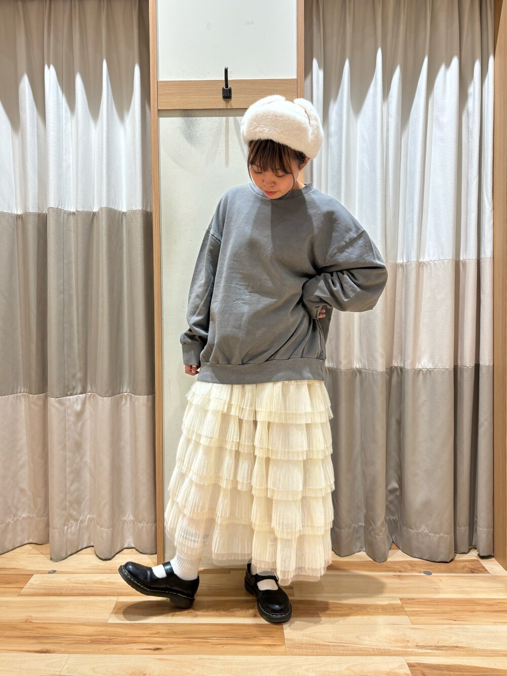 グレー系のTシャツ/カットソー、ホワイト系のスカート、ホワイト系のハットを着用したレディースの秋コーディネートの5枚目の写真