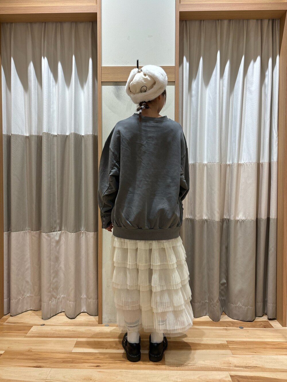 グレー系のTシャツ/カットソー、ホワイト系のスカート、ホワイト系のハットを着用したレディースの秋コーディネートの3枚目の写真