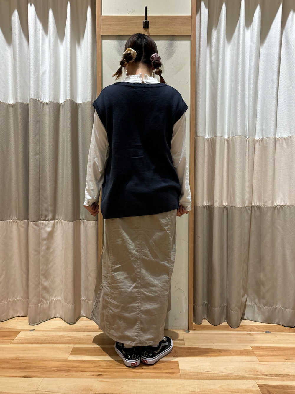 ホワイト系のTシャツ/カットソー、ブルー系のベスト、ベージュ系のワンピースを着用したレディースの秋コーディネートの3枚目の写真