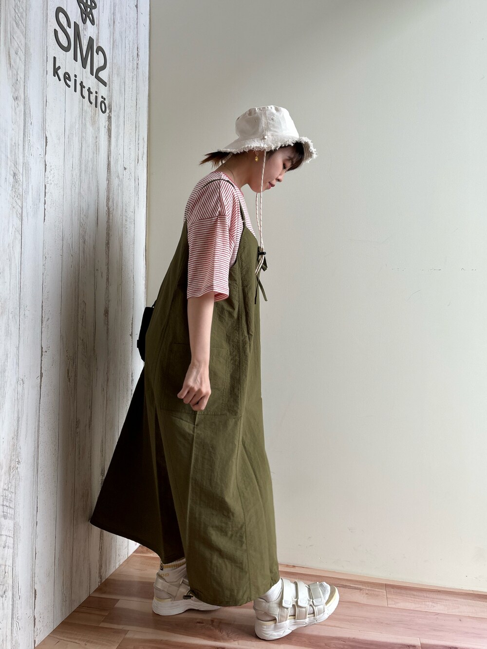 ピンク系のTシャツ/カットソー、グリーン系のワンピース/ドレス、ブラック系のハンドバッグを着用したレディースの春コーディネートの4枚目の写真