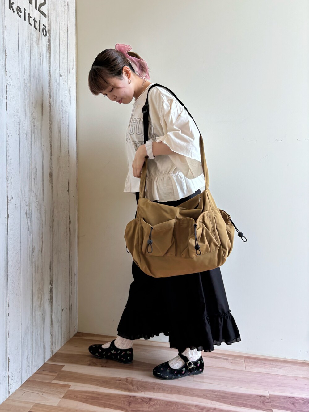 ホワイト系のTシャツ/カットソー、ブラック系のパンツ、ベージュ系のバッグを着用したレディースの夏コーディネートの4枚目の写真