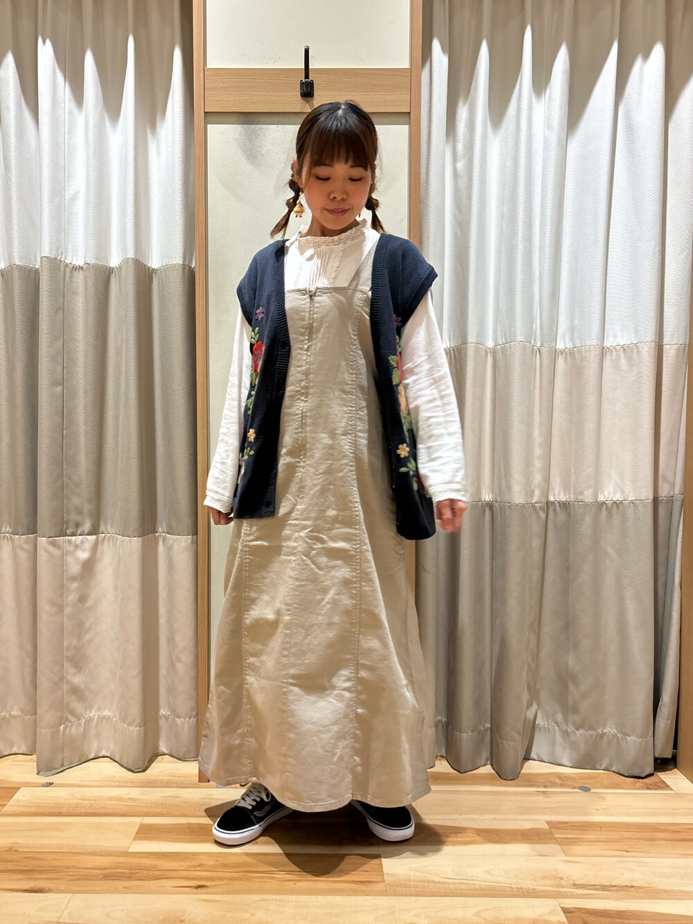 ホワイト系のTシャツ/カットソー、ブルー系のベスト、ベージュ系のワンピースを着用したレディースの秋コーディネートの4枚目の写真