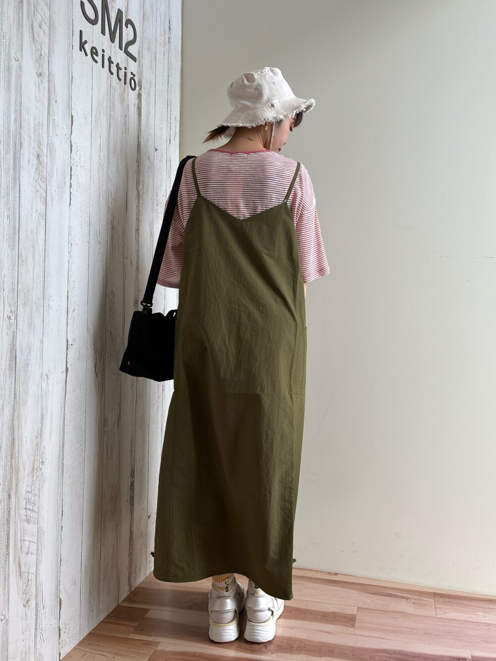 ピンク系のTシャツ/カットソー、グリーン系のワンピース/ドレス、ブラック系のハンドバッグを着用したレディースの春コーディネートの3枚目の写真