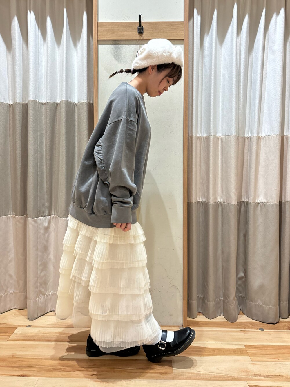 グレー系のTシャツ/カットソー、ホワイト系のスカート、ホワイト系のハットを着用したレディースの秋コーディネートの4枚目の写真