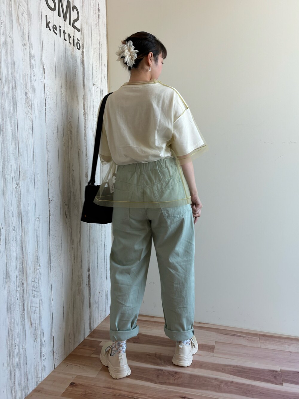 グリーン系のTシャツ/カットソー、グリーン系のパンツ、ブラック系のハンドバッグを着用したレディースの春コーディネートの5枚目の写真