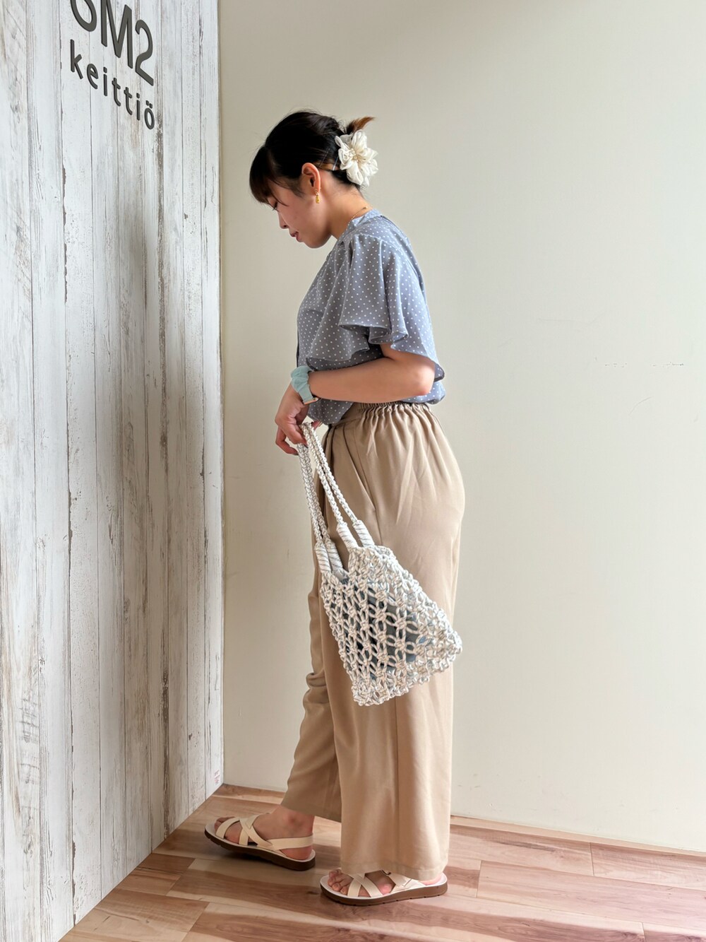 ブルー系のシャツ/ブラウス、グレー系のその他パンツ、ホワイト系のハンドバッグを着用したレディースの春コーディネートの2枚目の写真