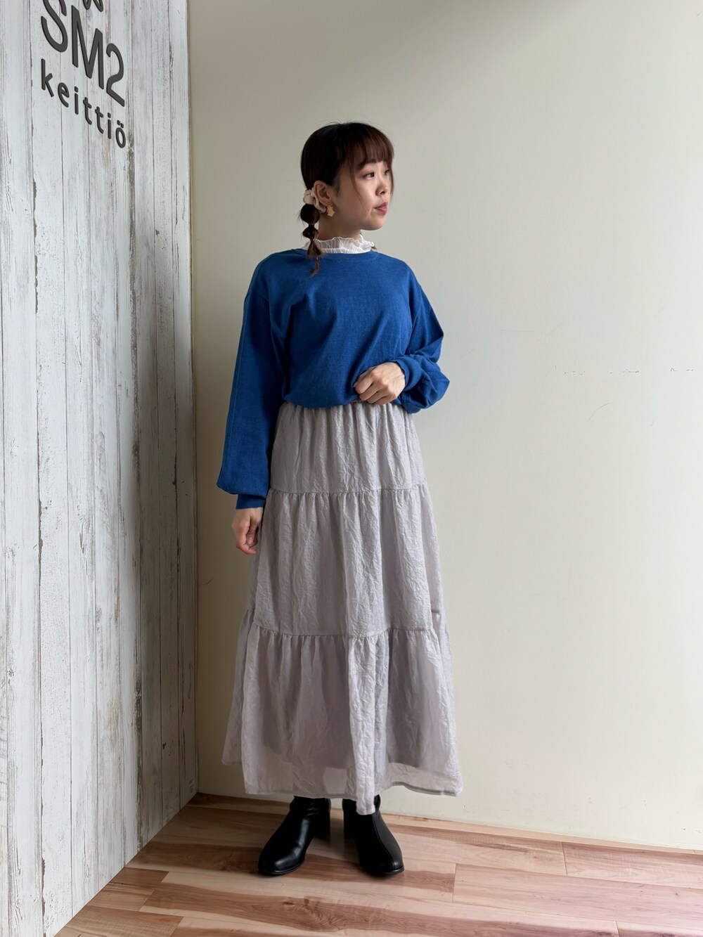 ブルー系のカーディガン/ボレロ、グレー系のスカート、ブラック系のドレスシューズを着用したレディースの秋コーディネートの2枚目の写真