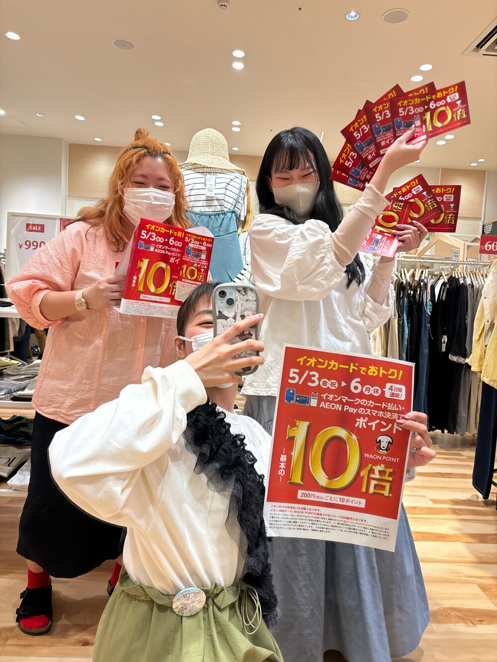 オレンジ系のシャツ/ブラウス、グリーン系のワンピース、ホワイト系のTシャツ/カットソーを着用したレディースの春コーディネートの2枚目の写真