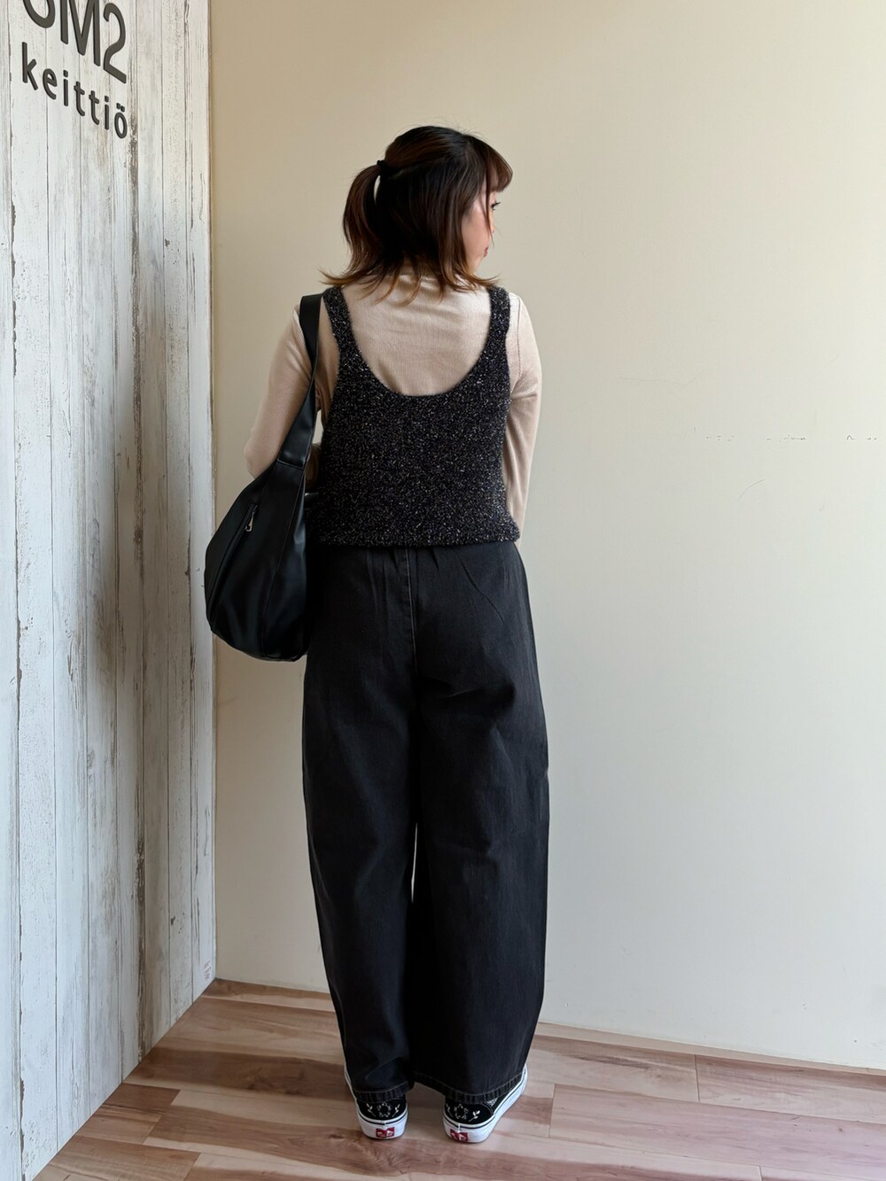 ベージュ系のTシャツ/カットソー、ブラック系のニット/セーター、ブラック系のハンドバッグを着用したレディースの秋コーディネートの3枚目の写真