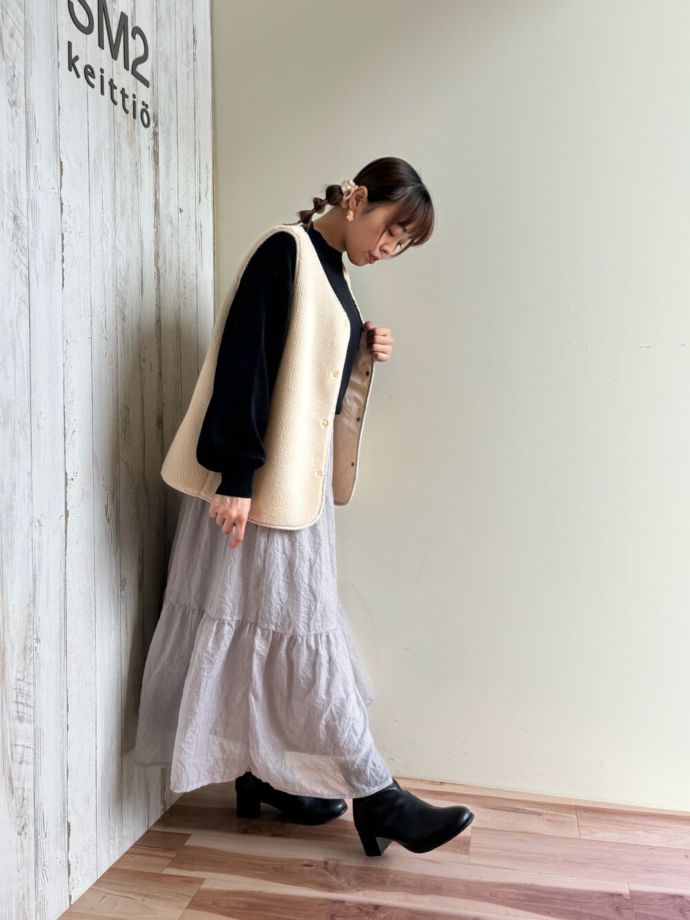 グレー系のスカート、ブラック系のドレスシューズ、グリーン系のニット/セーターを着用したレディースの秋コーディネートの2枚目の写真