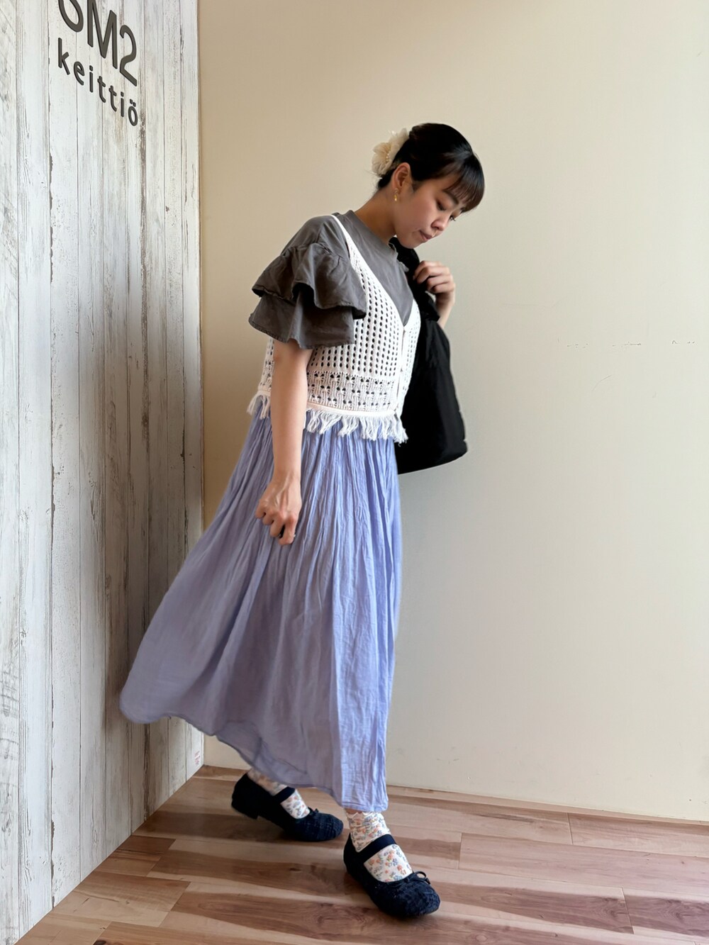 グレー系のTシャツ/カットソー、ホワイト系のニット/セーター、ブラック系のハンドバッグを着用したレディースの春コーディネートの4枚目の写真