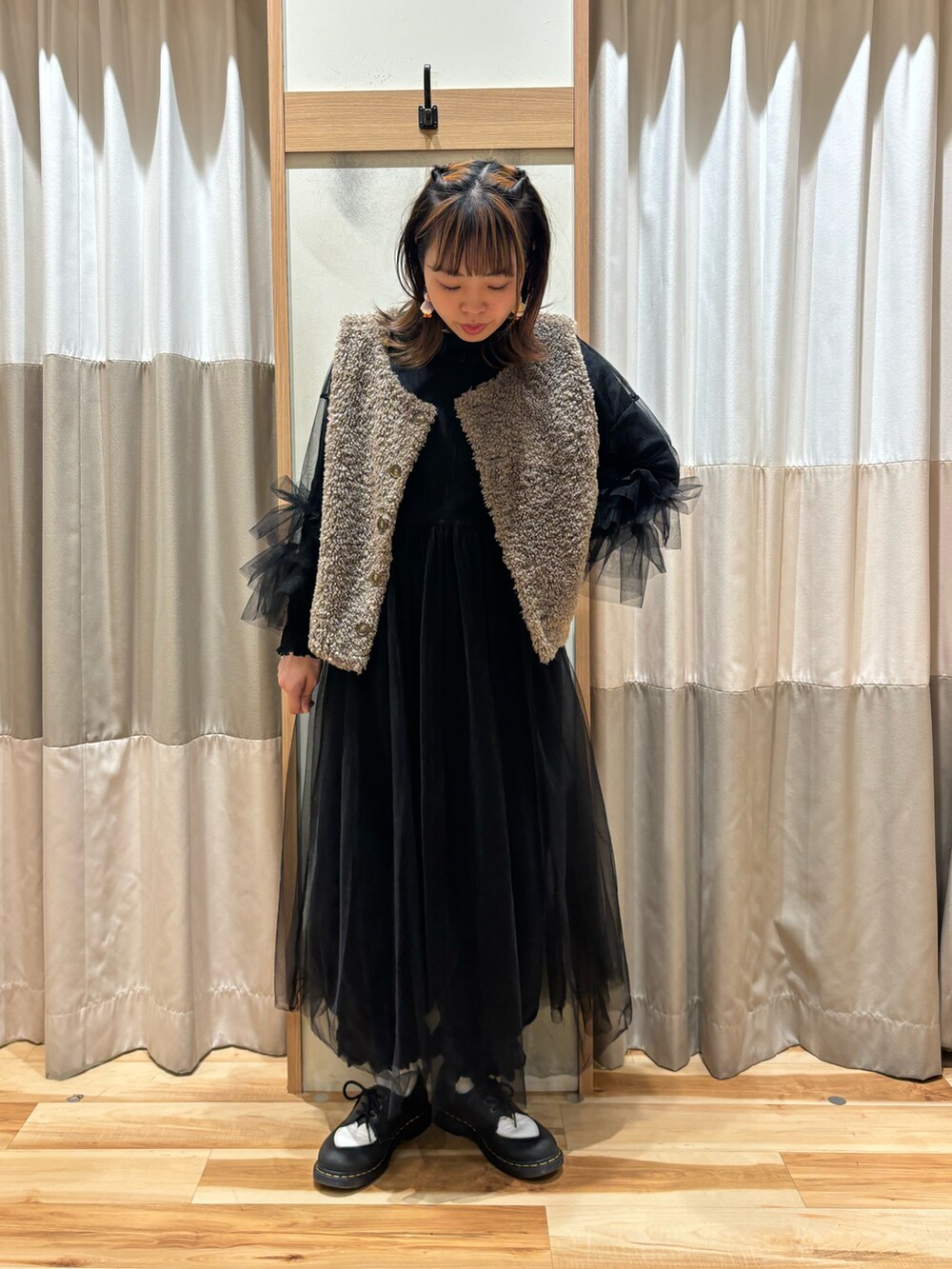 ブラウン系のベスト、ブラック系のワンピース、ブラック系のその他パンツを着用したレディースの秋コーディネートの4枚目の写真