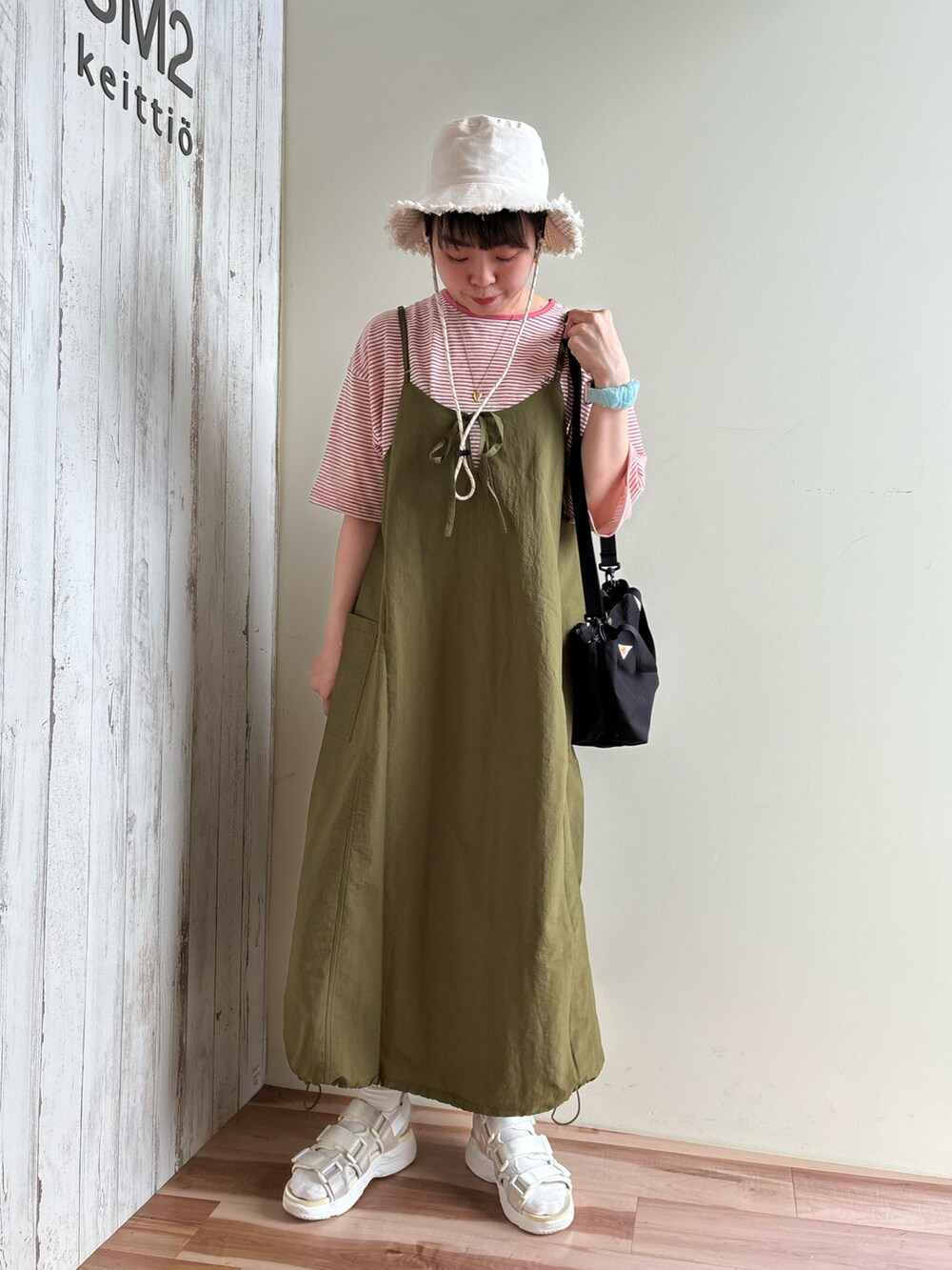 ピンク系のTシャツ/カットソー、グリーン系のワンピース/ドレス、ブラック系のハンドバッグを着用したレディースの春コーディネートの5枚目の写真