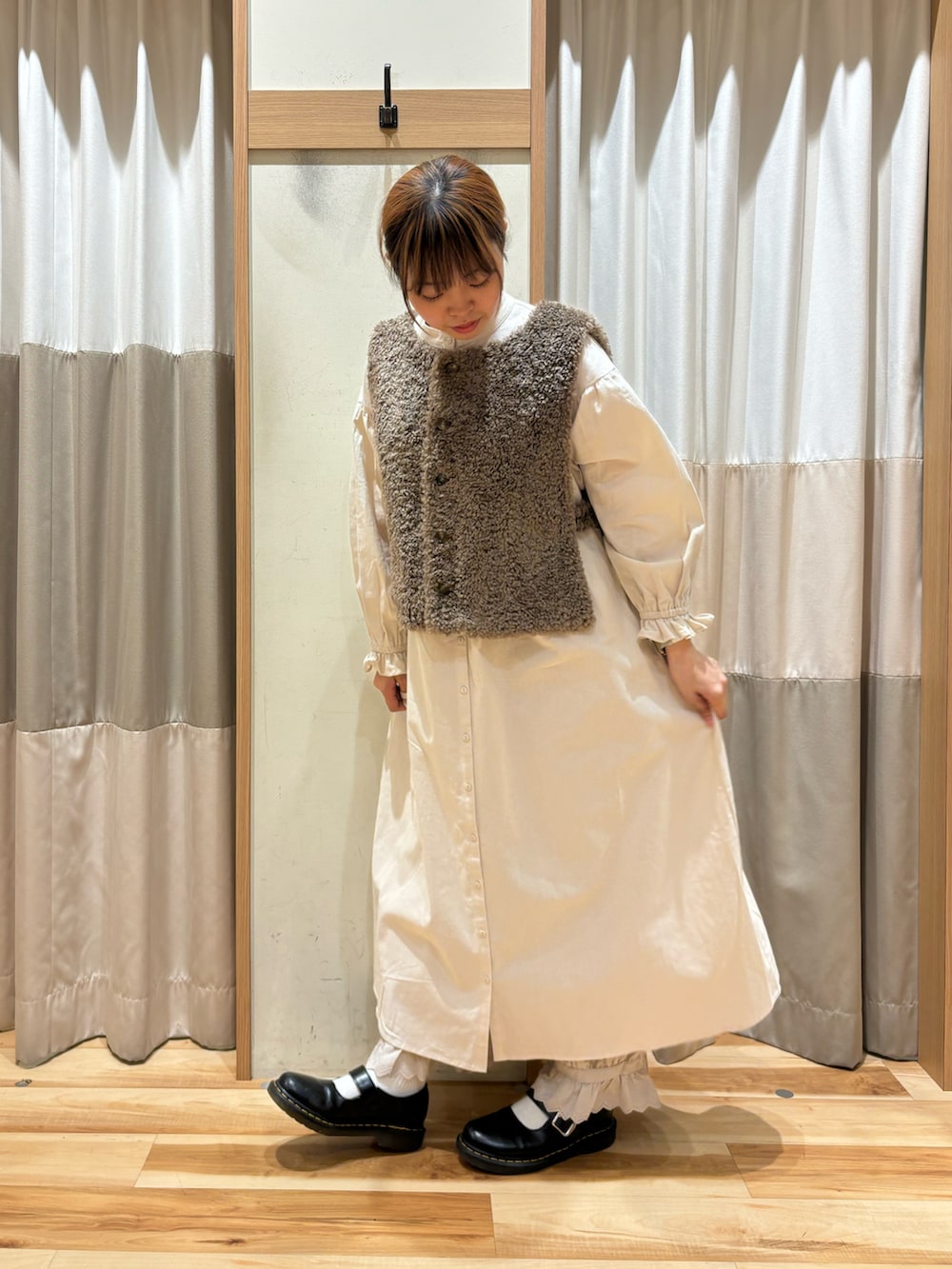 ホワイト系のワンピース、ベージュ系のその他パンツ、ブラウン系のベストを着用したレディースの秋コーディネートの2枚目の写真