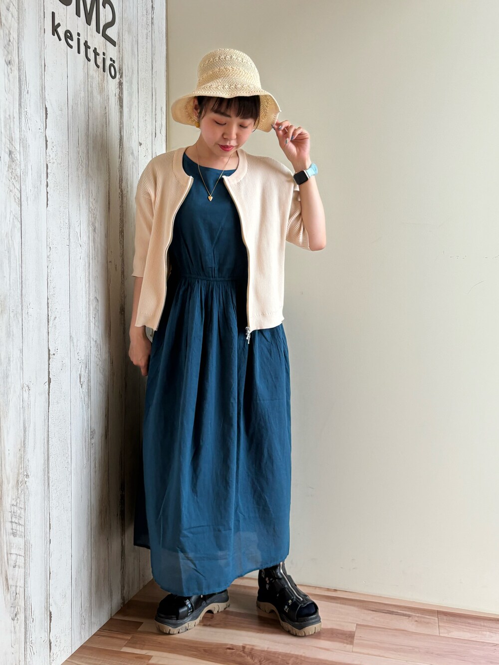 ホワイト系のカーディガン/ボレロ、ブルー系のワンピース、ブラック系のサンダルを着用したレディースの春コーディネートの5枚目の写真