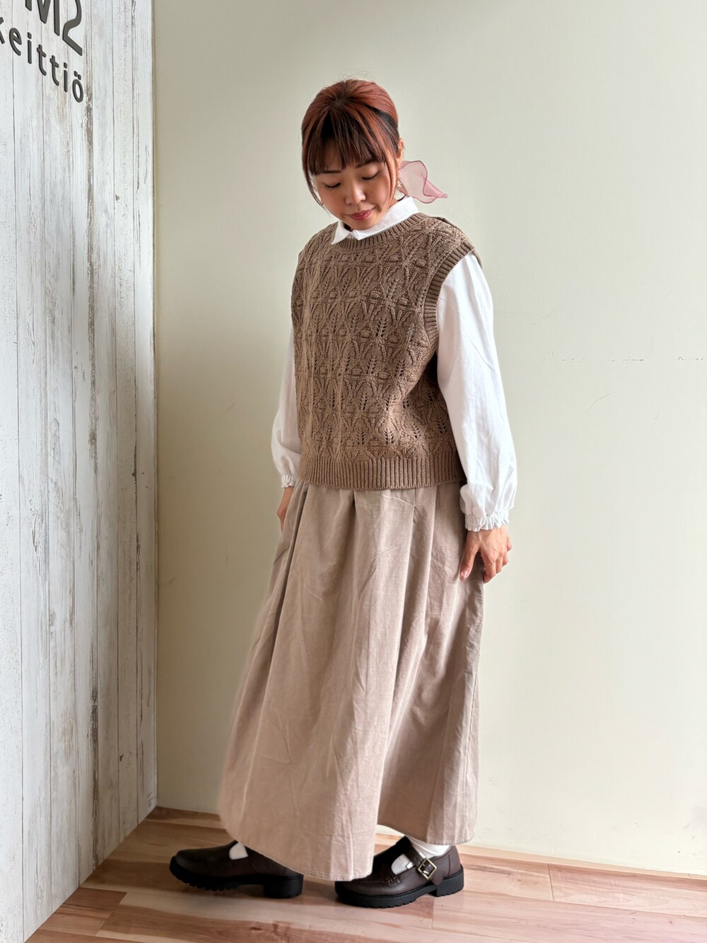 ブラウン系のベスト、ホワイト系のシャツ/ブラウス、ベージュ系のスカートを着用したレディースの秋コーディネートの2枚目の写真