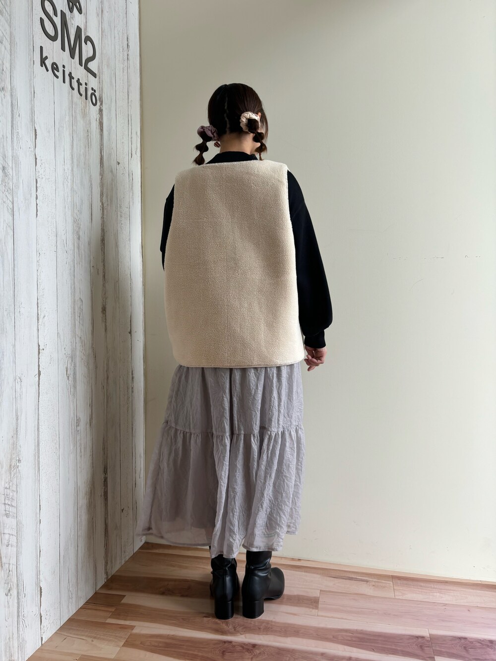 グレー系のスカート、ブラック系のドレスシューズ、グリーン系のニット/セーターを着用したレディースの秋コーディネートの3枚目の写真