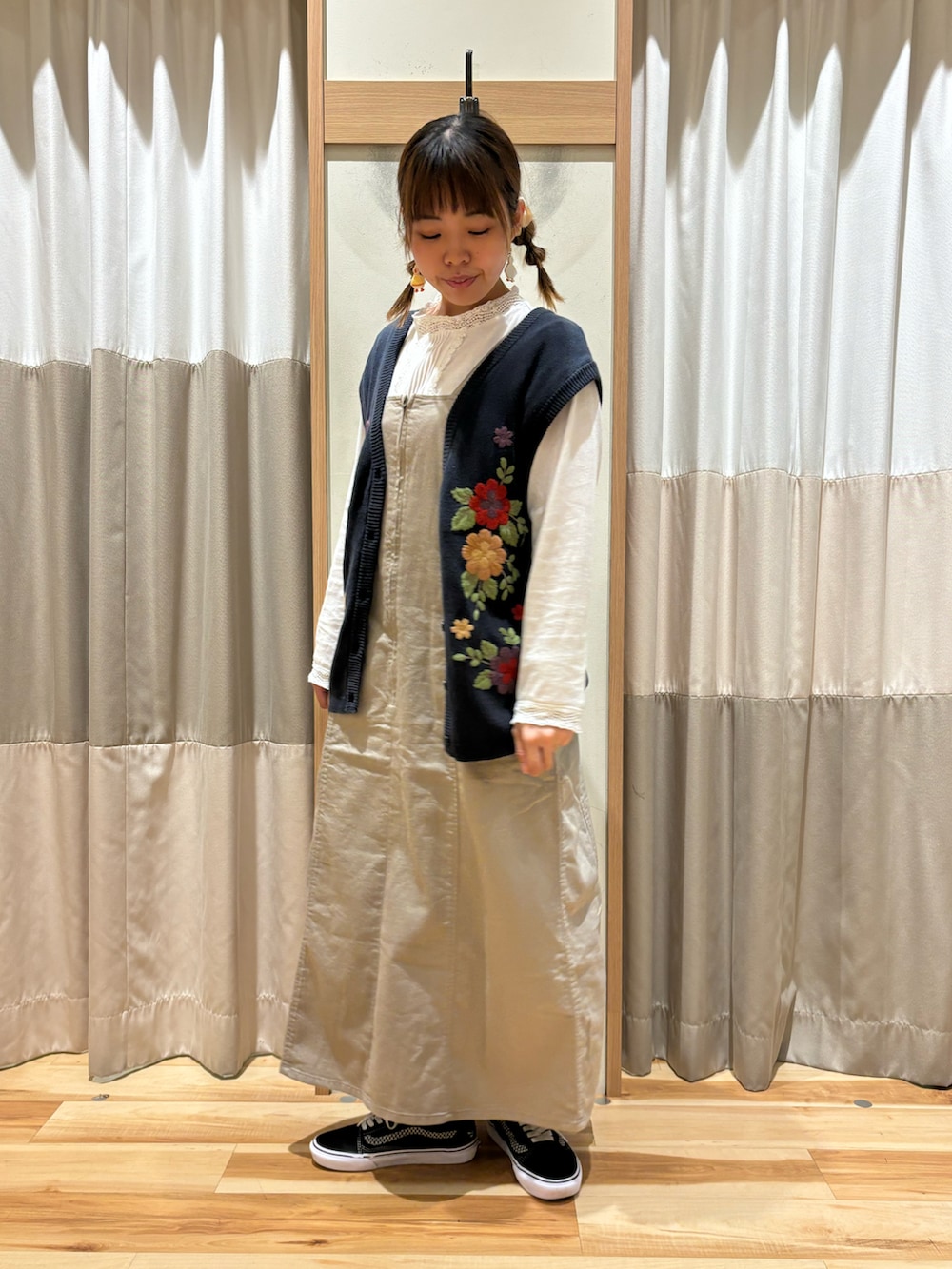 ホワイト系のTシャツ/カットソー、ブルー系のベスト、ベージュ系のワンピースを着用したレディースの秋コーディネートの2枚目の写真