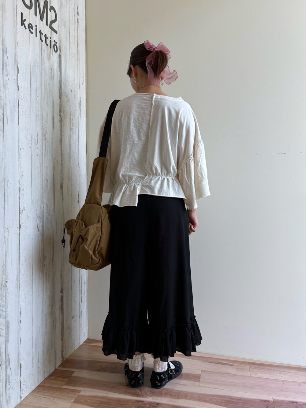 ホワイト系のTシャツ/カットソー、ブラック系のパンツ、ベージュ系のバッグを着用したレディースの夏コーディネートの3枚目の写真