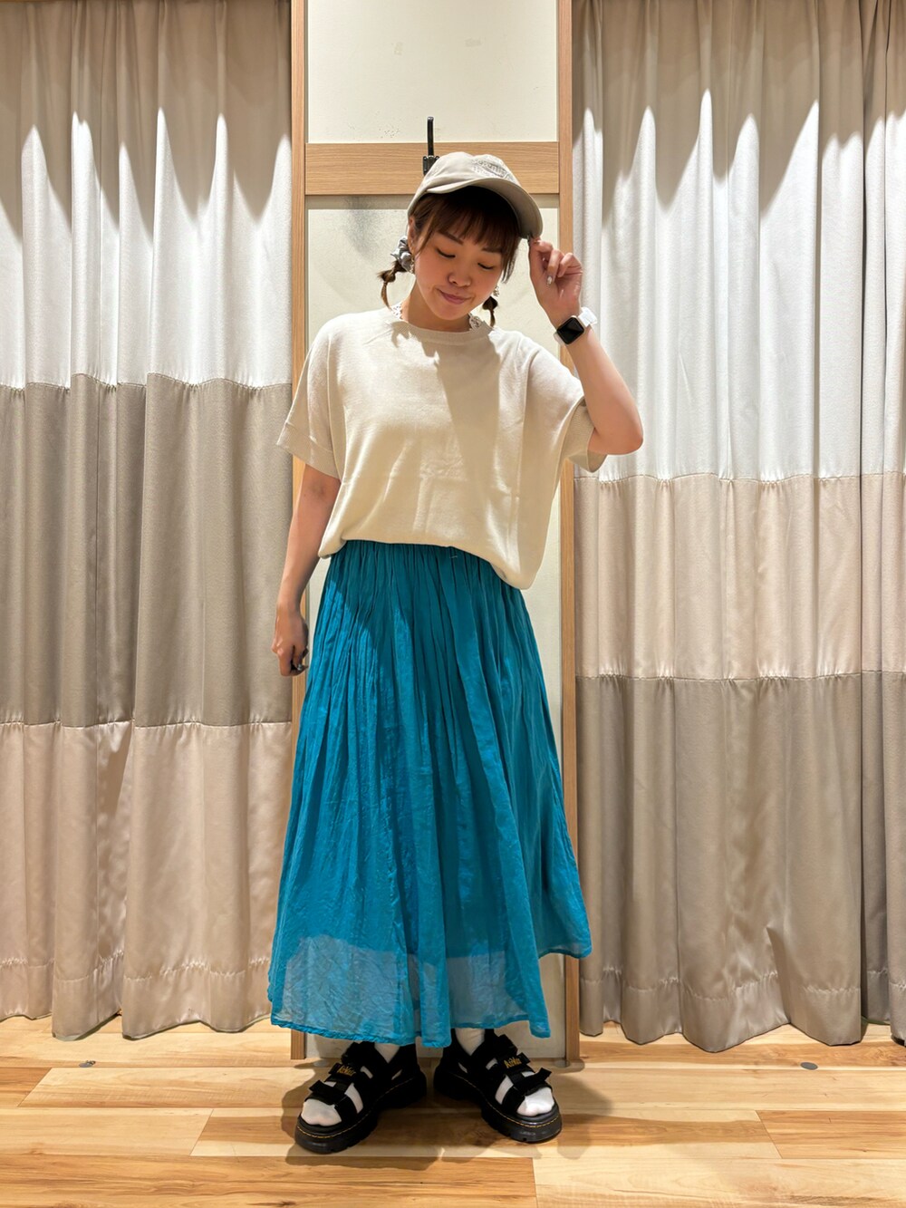 ブルー系のスカート、ブルー系のニット/セーター、ベージュ系のハットを着用したレディースの夏コーディネートの3枚目の写真