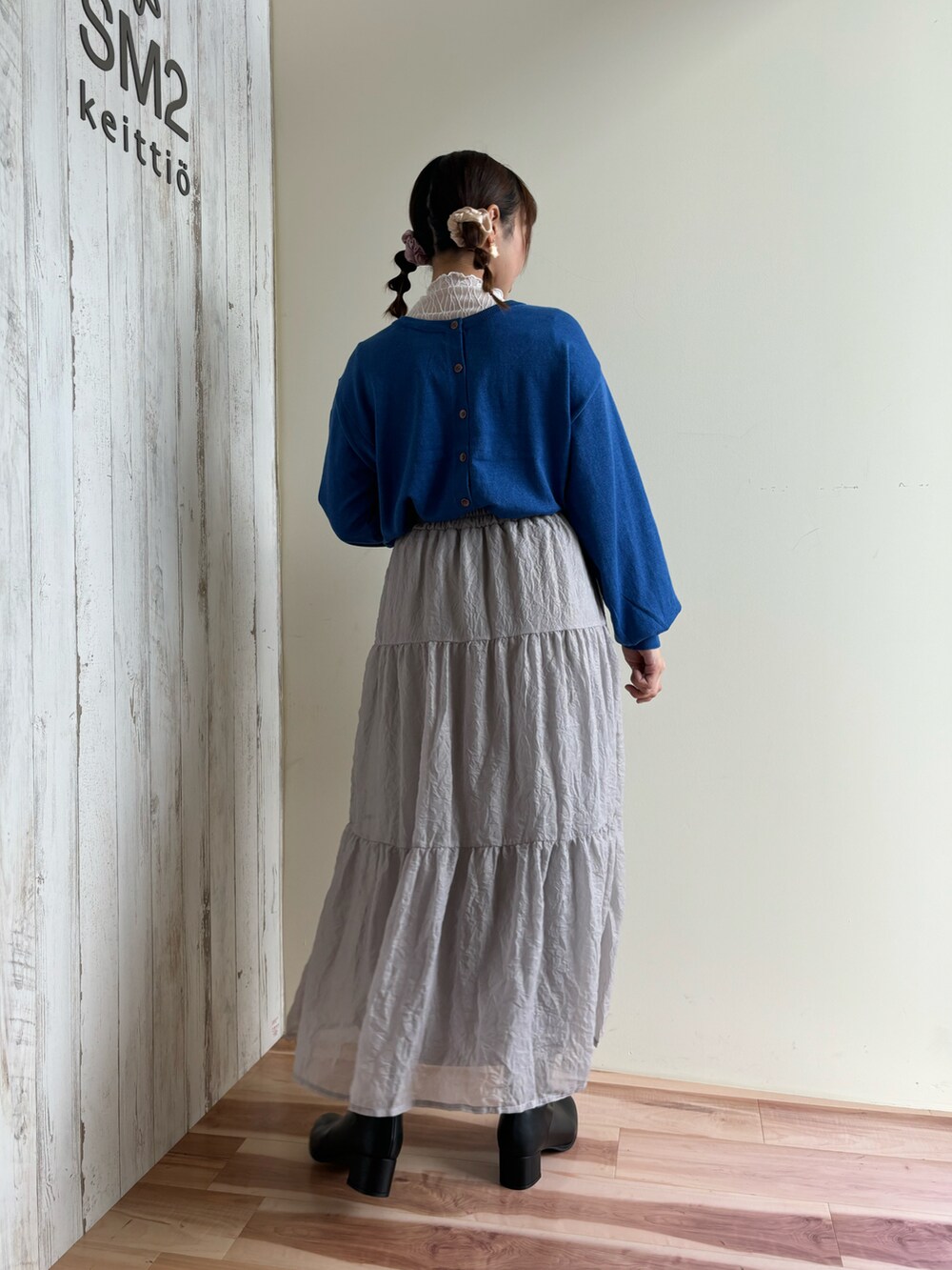 ブルー系のカーディガン/ボレロ、グレー系のスカート、ブラック系のドレスシューズを着用したレディースの秋コーディネートの3枚目の写真