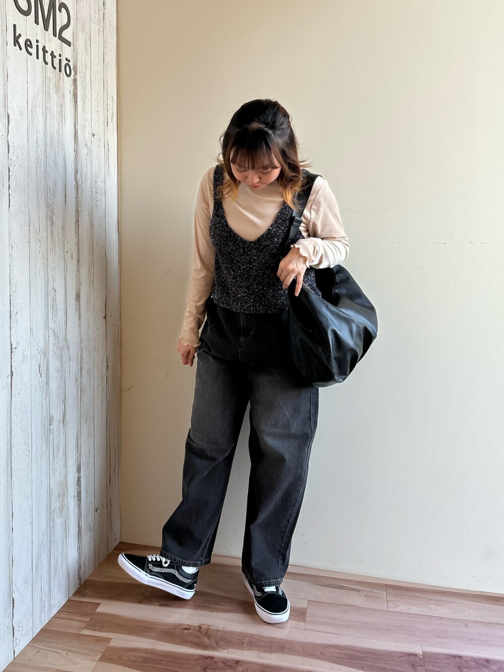 ベージュ系のTシャツ/カットソー、ブラック系のニット/セーター、ブラック系のハンドバッグを着用したレディースの秋コーディネートの5枚目の写真