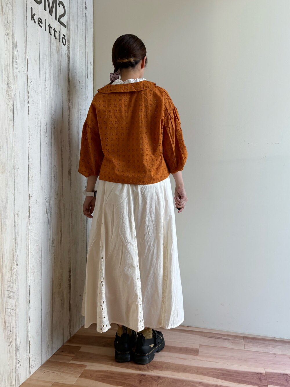 ホワイト系のスカート、オレンジ系のシャツ/ブラウス、ホワイト系のTシャツ/カットソーを着用したレディースの夏コーディネートの3枚目の写真