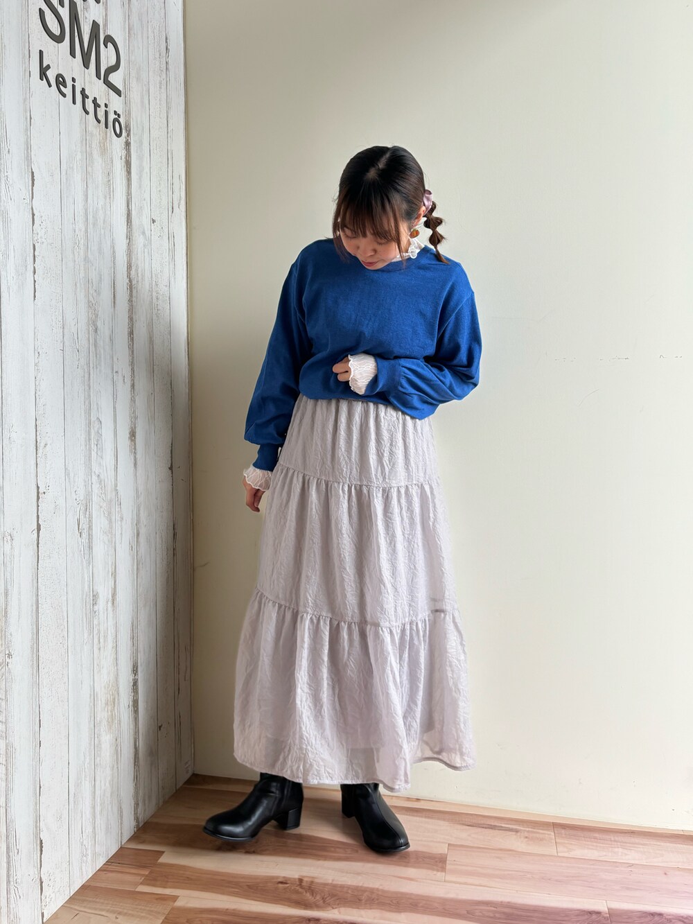 ブルー系のカーディガン/ボレロ、グレー系のスカート、ブラック系のドレスシューズを着用したレディースの秋コーディネートの4枚目の写真