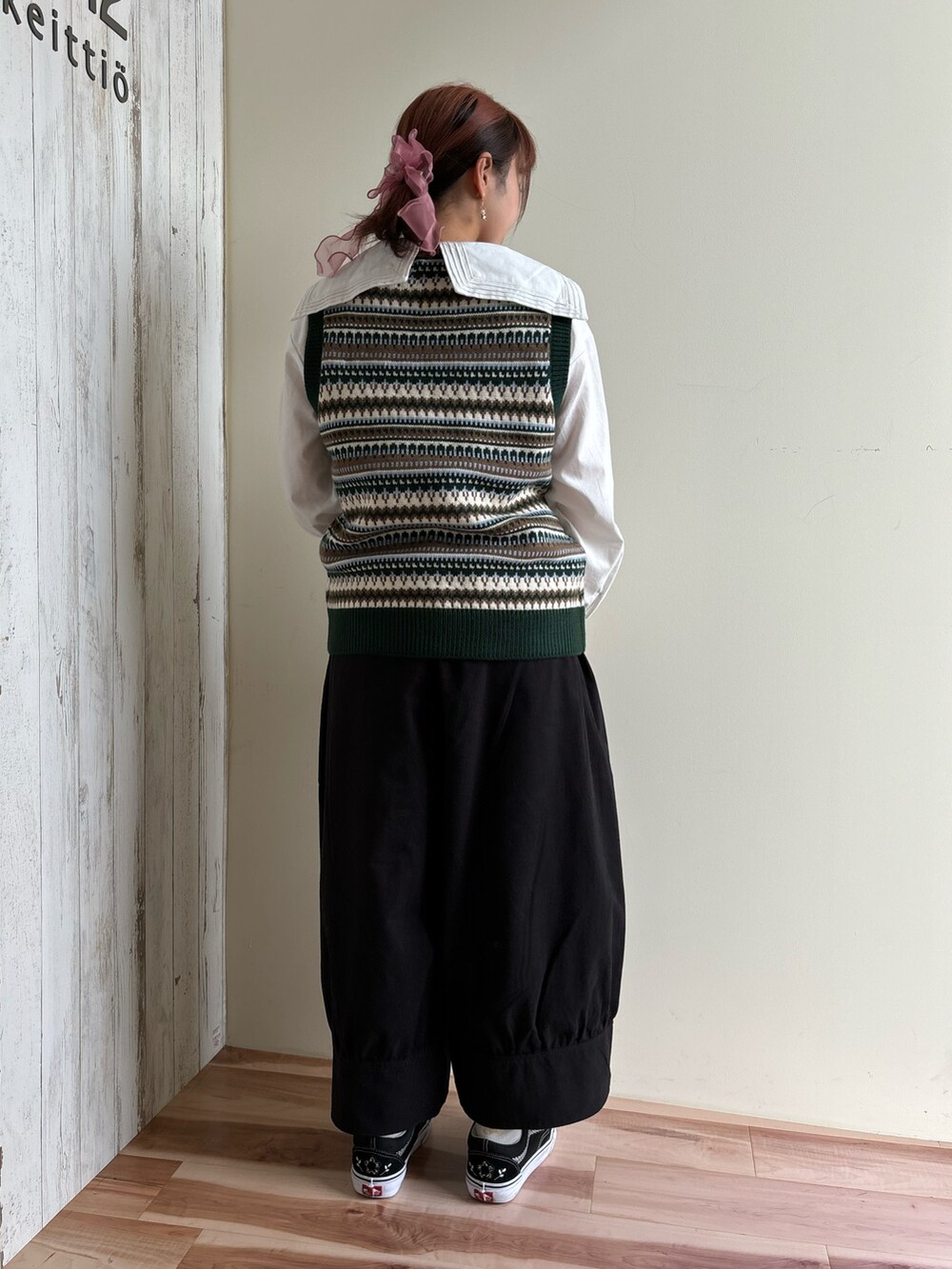 ホワイト系のシャツ/ブラウス、ブラック系のその他パンツ、グリーン系のベストを着用したレディースの秋コーディネートの2枚目の写真