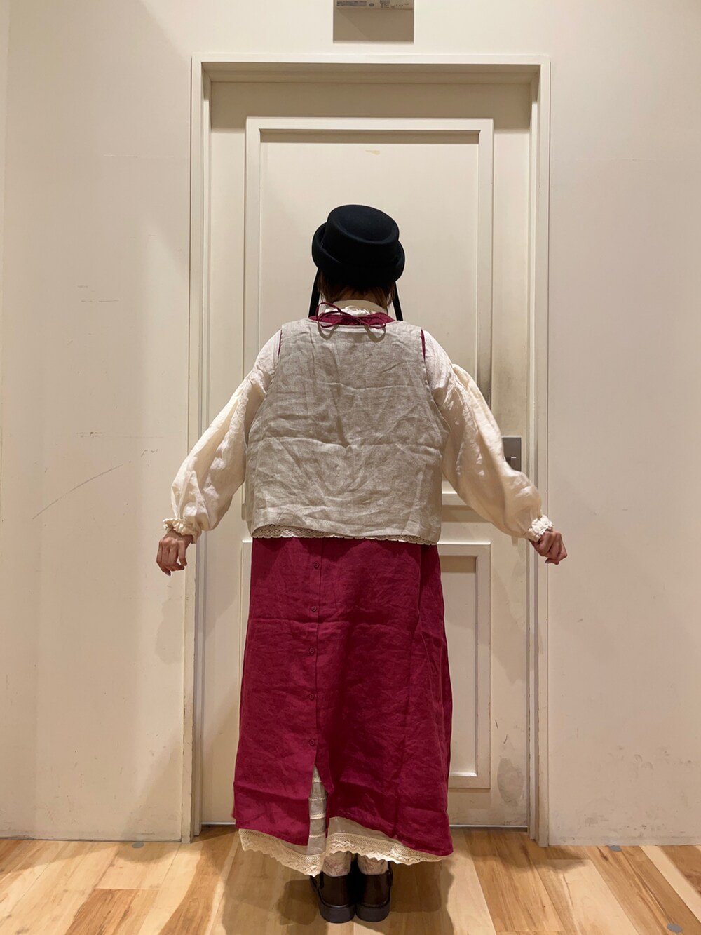 ホワイト系のシャツ/ブラウス、ベージュ系のベスト、レッド系のワンピースを着用したレディースの夏コーディネートの2枚目の写真