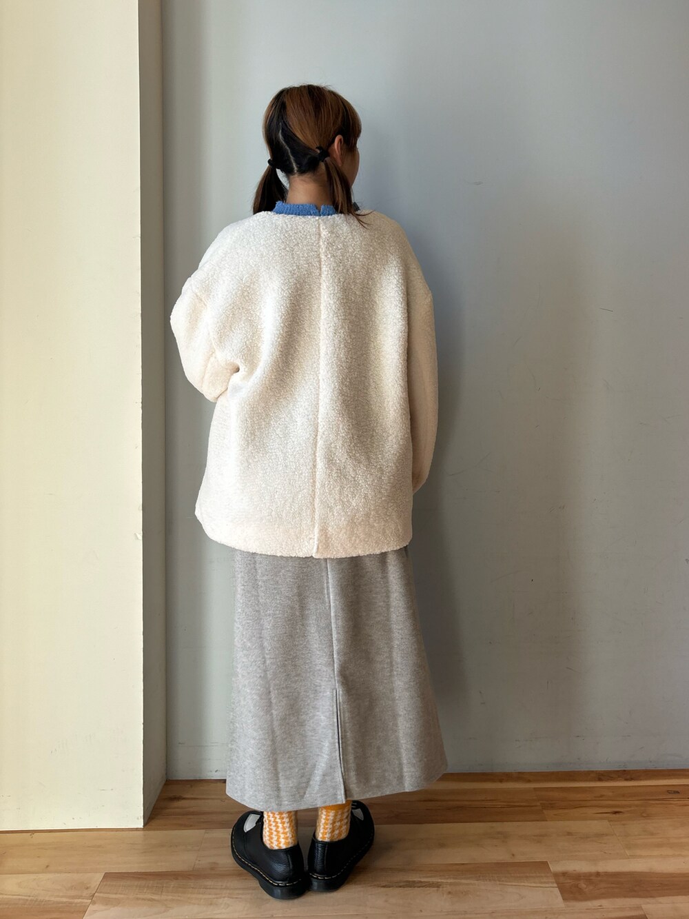 ブルー系のニット/セーター、ホワイト系のその他アウター、グレー系のスカートを着用したレディースの冬コーディネートの3枚目の写真