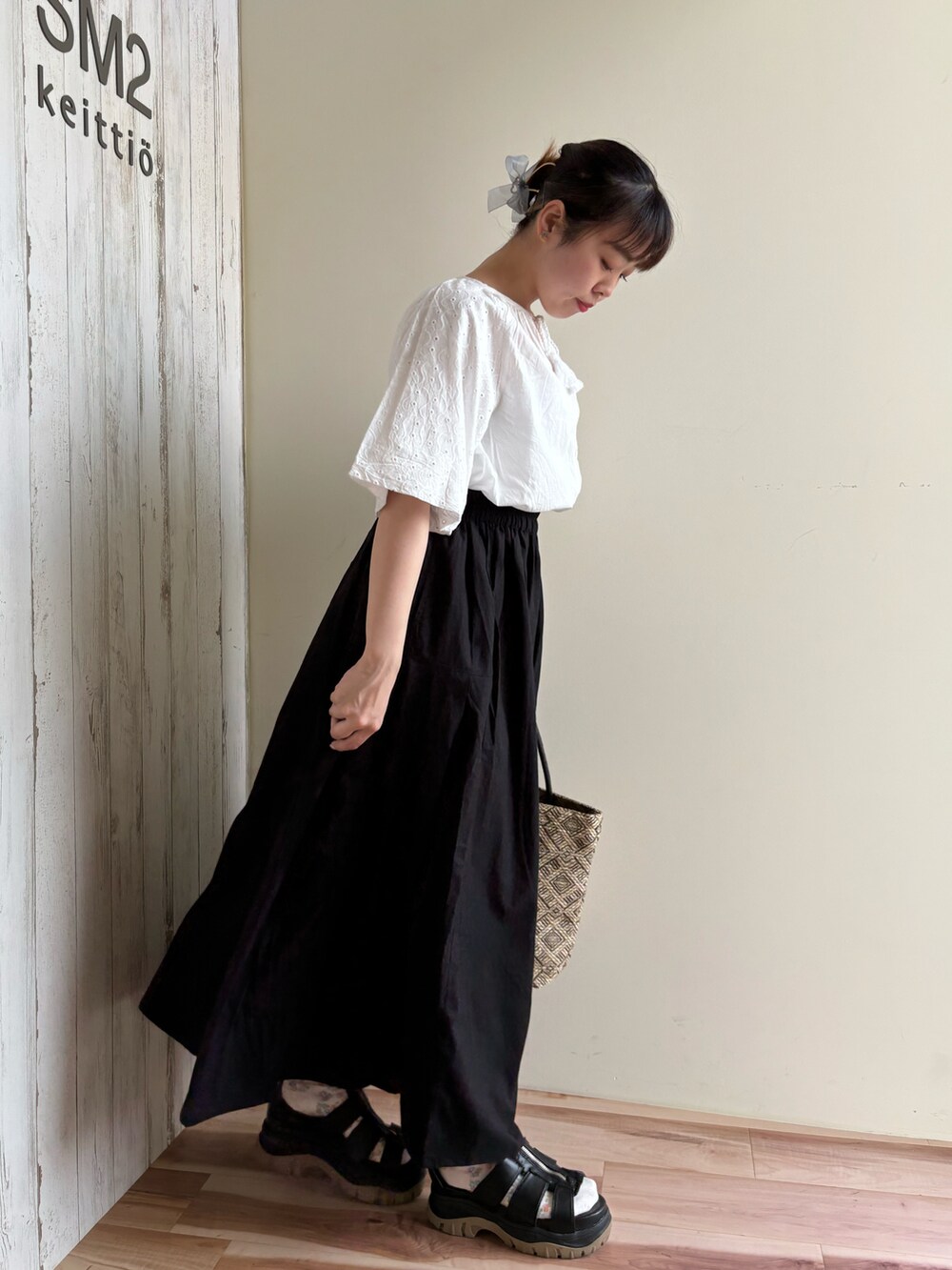 ホワイト系のシャツ/ブラウス、ブラック系のスカート、ブラック系のハンドバッグを着用したレディースの春コーディネートの2枚目の写真