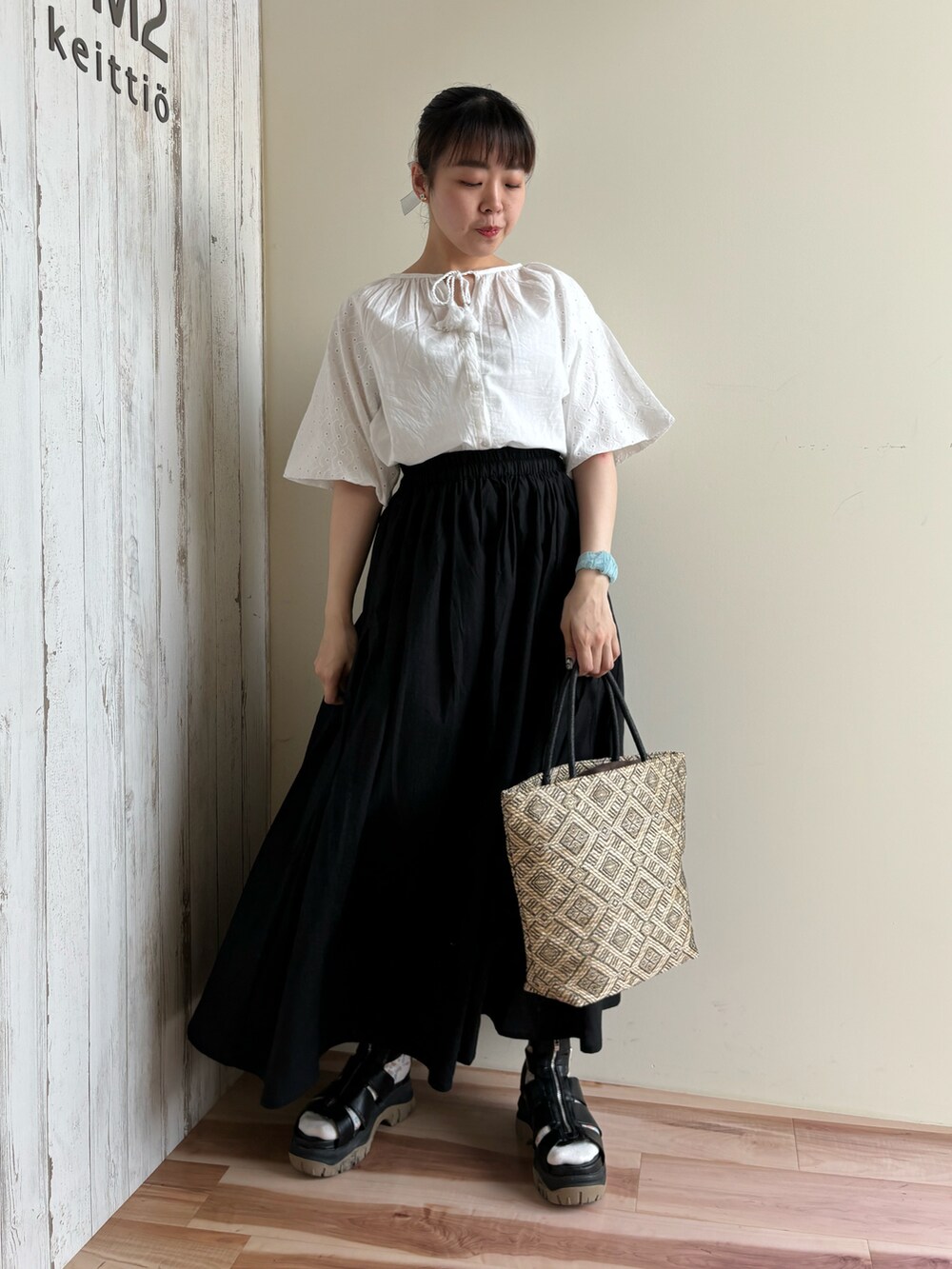 ホワイト系のシャツ/ブラウス、ブラック系のスカート、ブラック系のハンドバッグを着用したレディースの春コーディネートの5枚目の写真