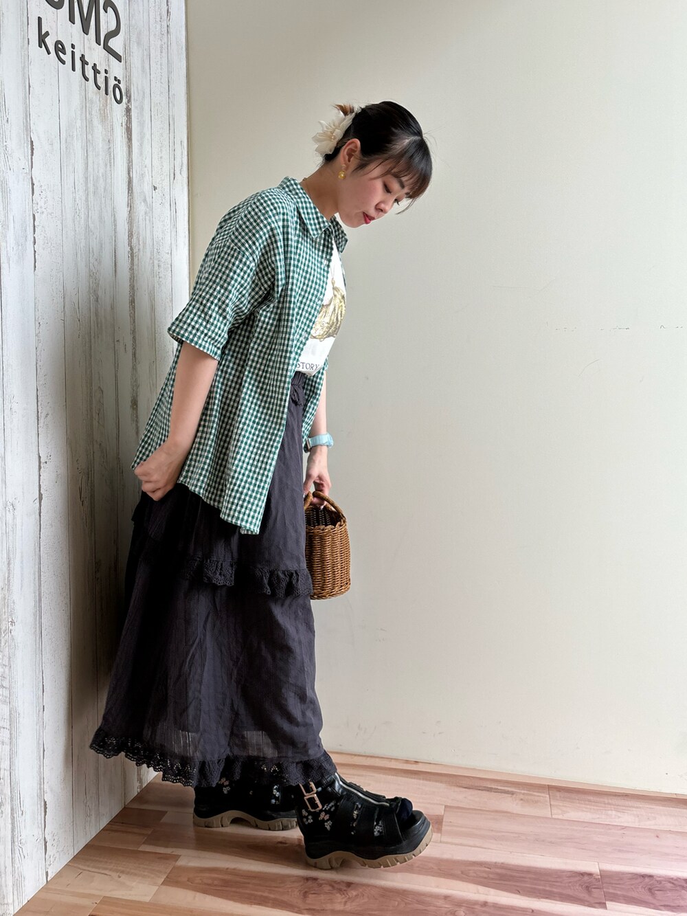 グリーン系のシャツ/ブラウス、ホワイト系のTシャツ/カットソー、ブラック系のスカートを着用したレディースの春コーディネートの4枚目の写真