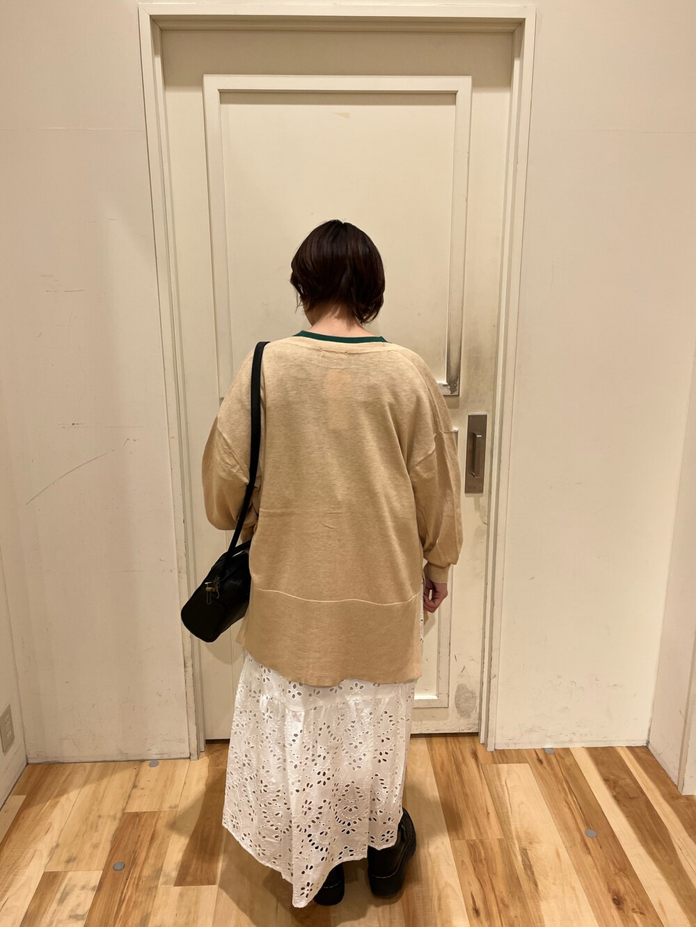 ホワイト系のカーディガン/ボレロ、グリーン系のTシャツ/カットソー、ホワイト系のスカートを着用したレディースの春コーディネートの2枚目の写真