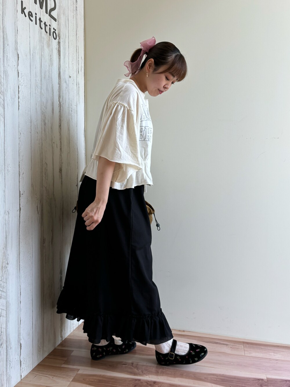 ホワイト系のTシャツ/カットソー、ブラック系のパンツ、ベージュ系のバッグを着用したレディースの夏コーディネートの2枚目の写真