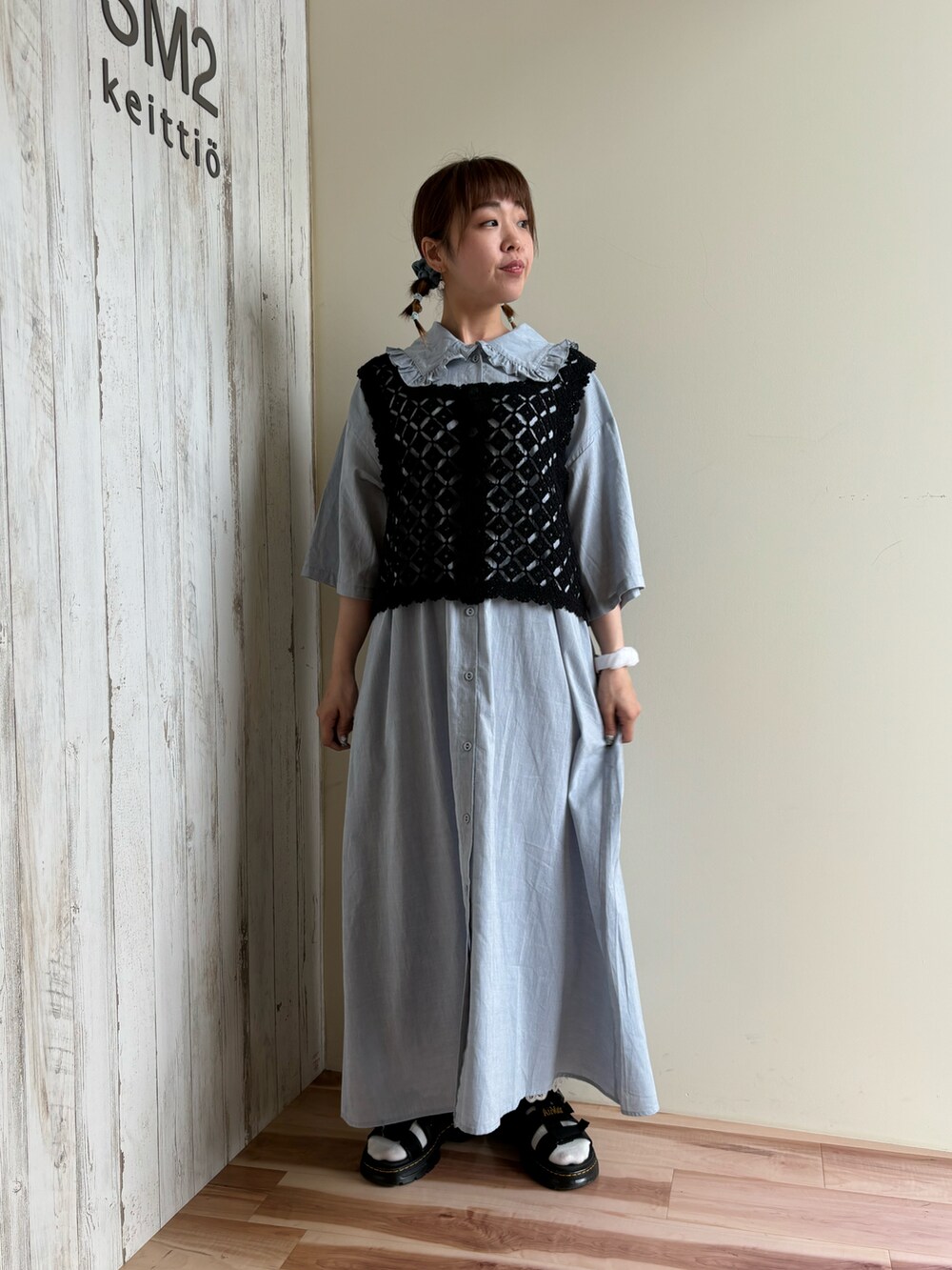 ブラック系のベスト、ブルー系のワンピース、ブラック系のサンダルを着用したレディースの夏コーディネートの5枚目の写真