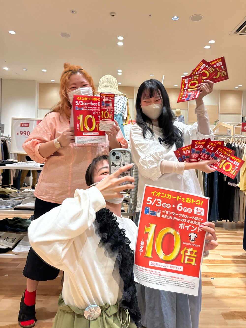 オレンジ系のシャツ/ブラウス、グリーン系のワンピース、ホワイト系のTシャツ/カットソーを着用したレディースの春コーディネートの3枚目の写真