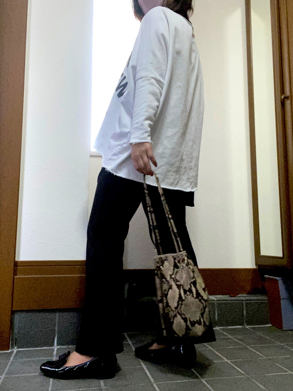 ホワイト系のスウェット、ブラック系のタンクトップ、ブラック系のその他パンツを着用したレディースの春コーディネートの2枚目の写真