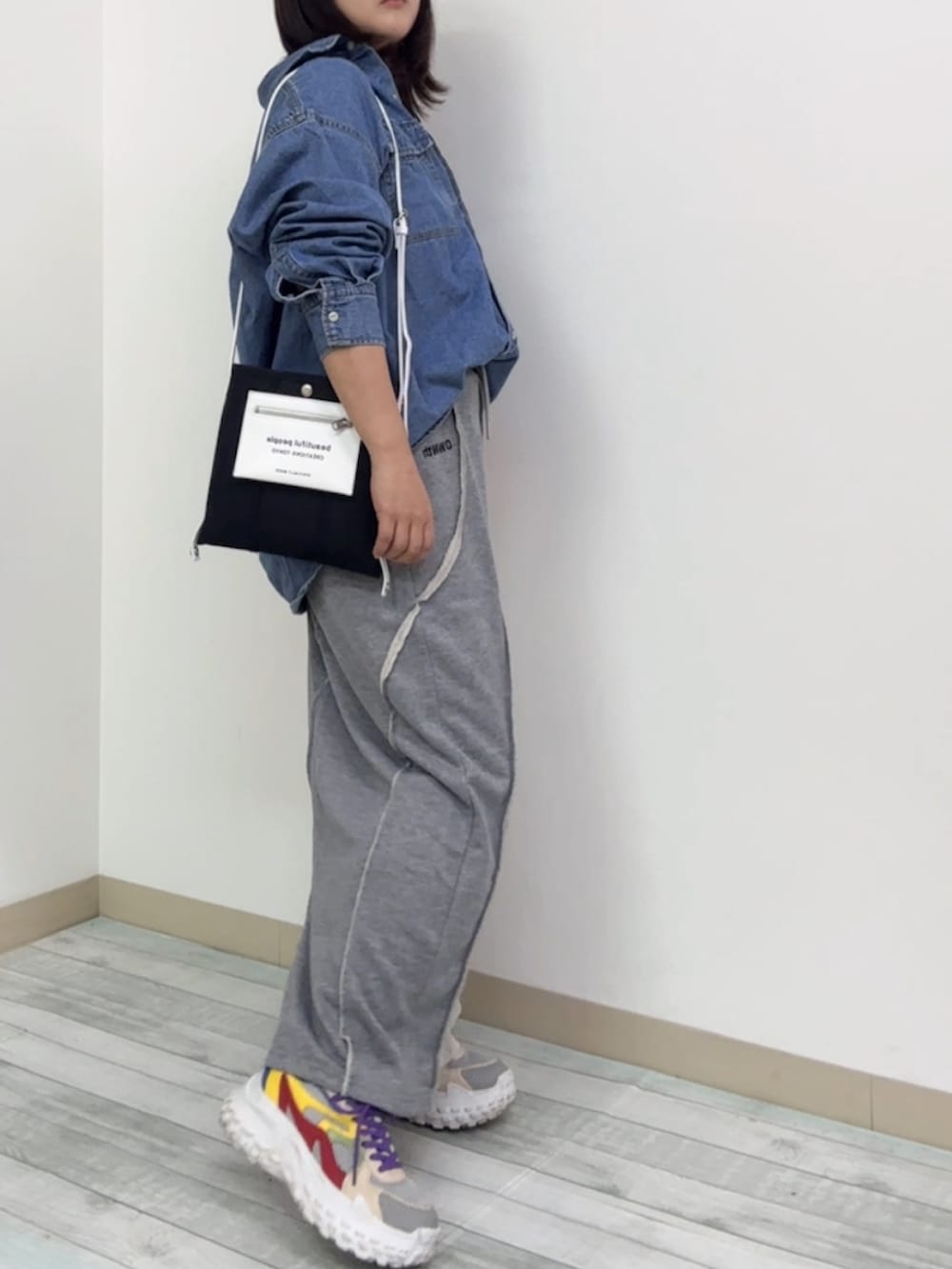 グレー系のスカート、ブルー系のシャツ/ブラウス、レッド系のスニーカーを着用したレディースの秋コーディネートの2枚目の写真