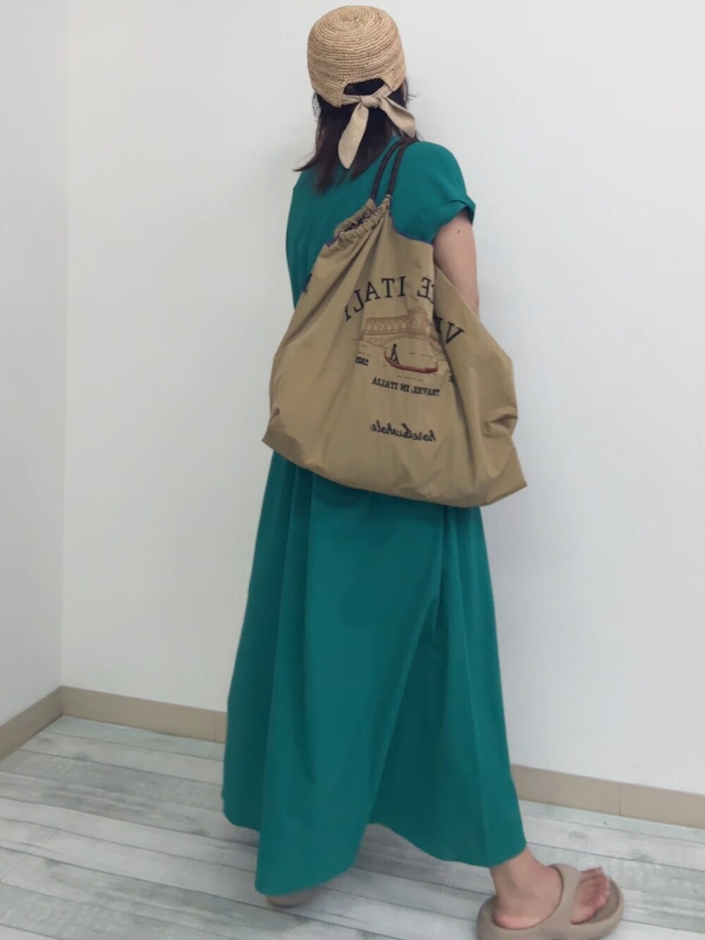 ベージュ系のハンドバッグ、グリーン系のワンピース、ベージュ系のビーチサンダルを着用したレディースの夏コーディネートの2枚目の写真