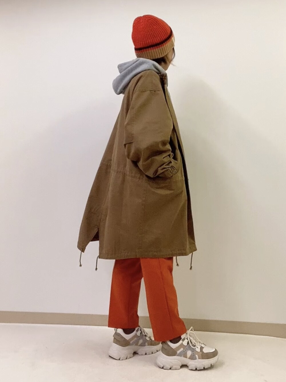 ベージュ系のスニーカー、ホワイト系のショルダーバッグ、グレー系のパーカーを着用したレディースの冬コーディネートの2枚目の写真