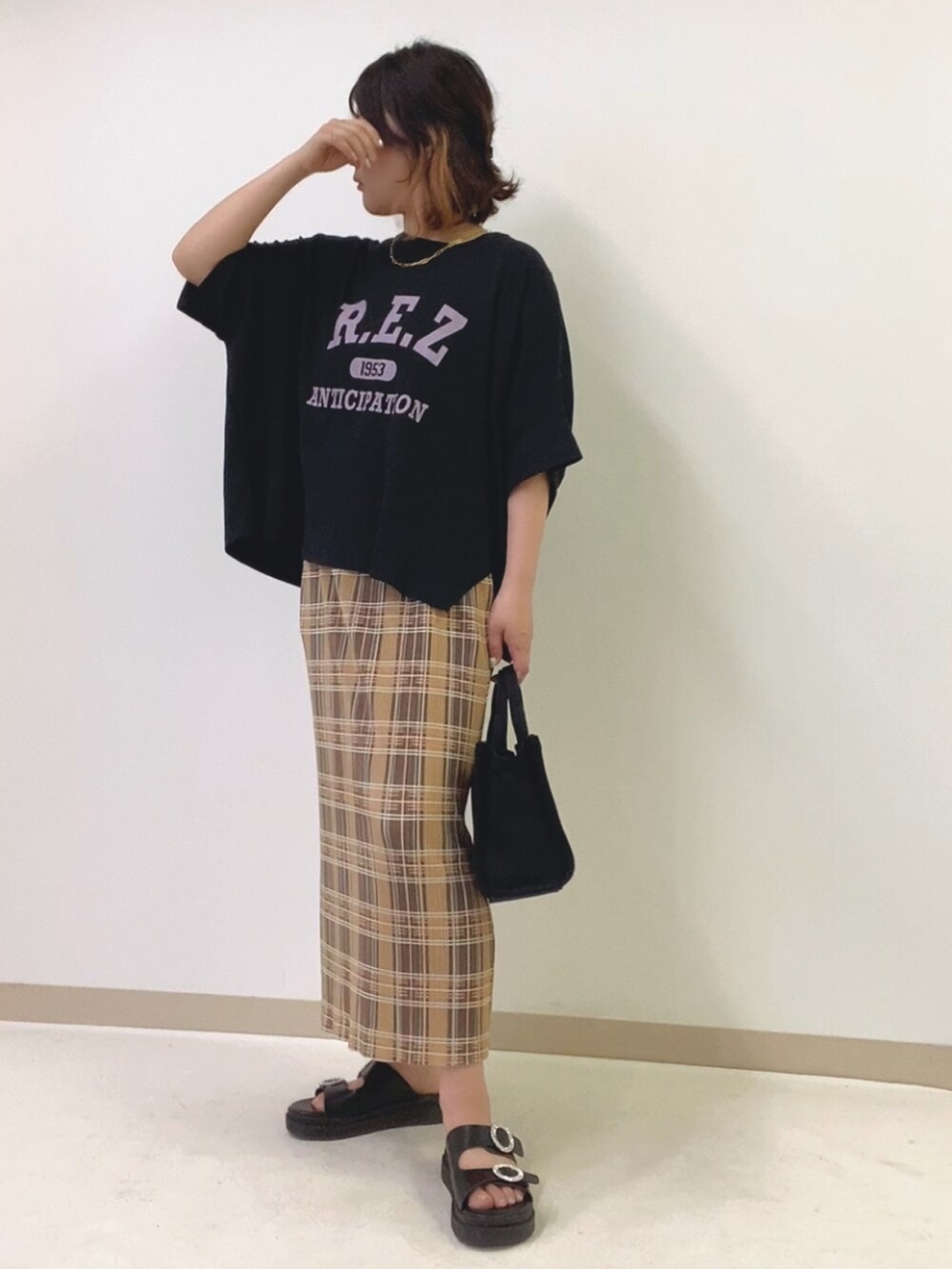 ブラック系のトートバッグ、ブラック系のTシャツ/カットソー、ブラック系のサンダルを着用したレディースの春コーディネートの2枚目の写真