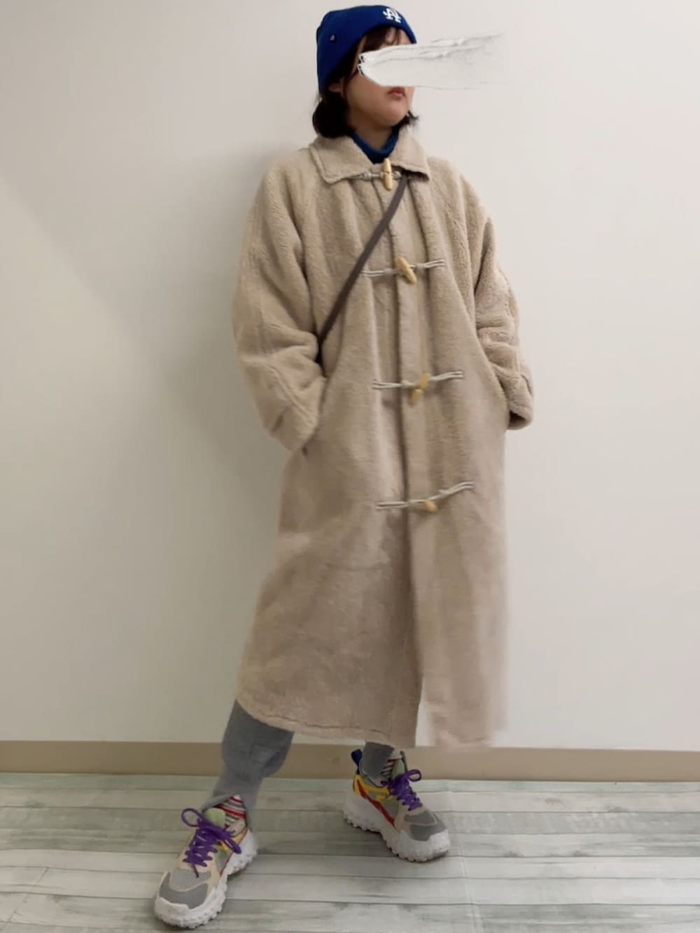 ベージュ系のムートンコート、グレー系のスウェット、グレー系のその他パンツを着用したレディースの冬コーディネートの2枚目の写真
