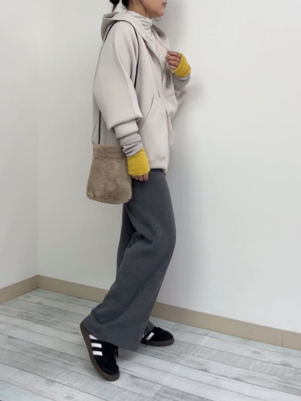 ベージュ系のパーカー、グレー系のその他パンツ、ブラック系のスニーカーを着用したレディースの冬コーディネートの2枚目の写真