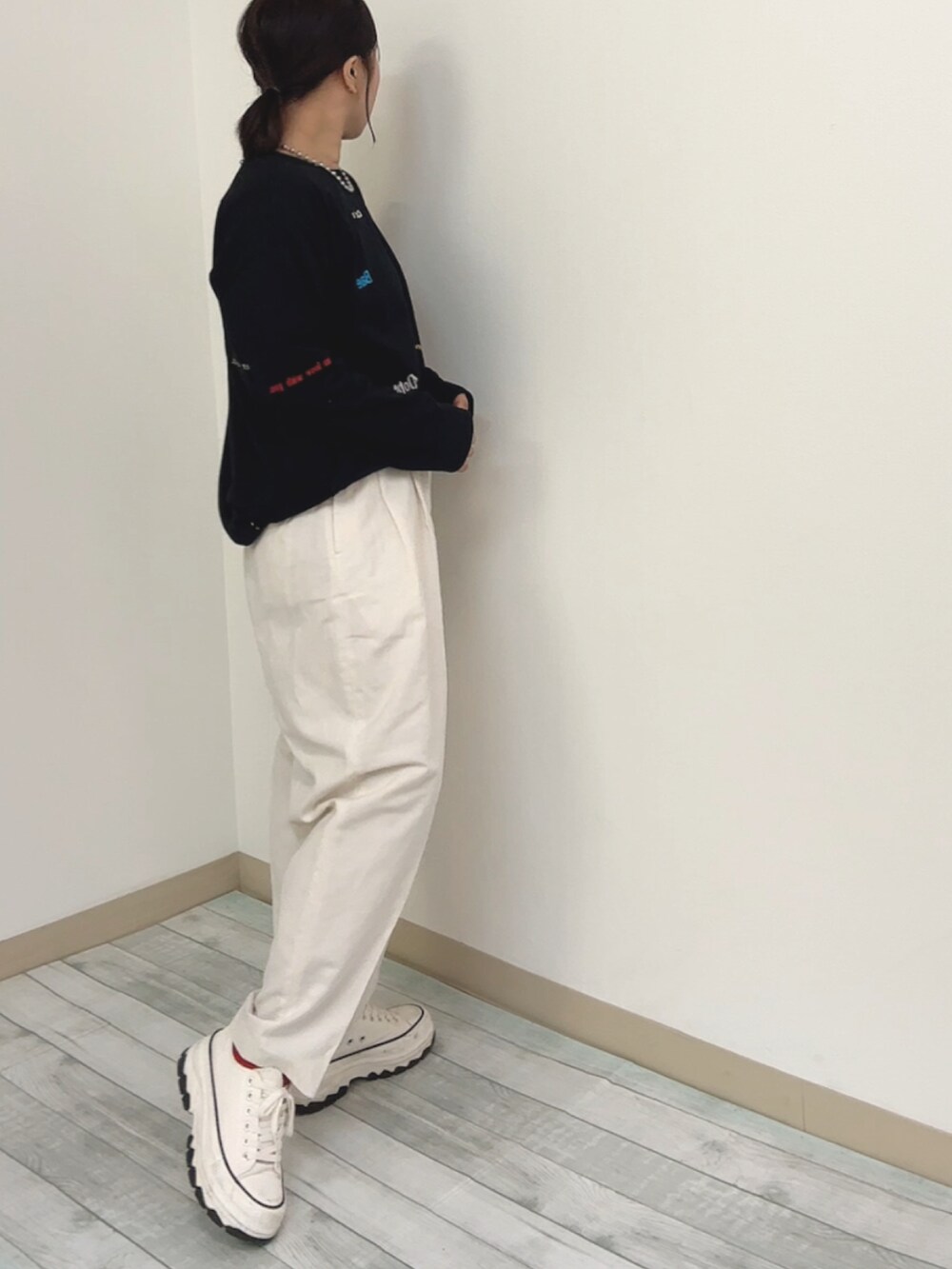 ブラック系のTシャツ/カットソー、ホワイト系のパンツ、ホワイト系のスニーカーを着用したレディースの春コーディネートの2枚目の写真