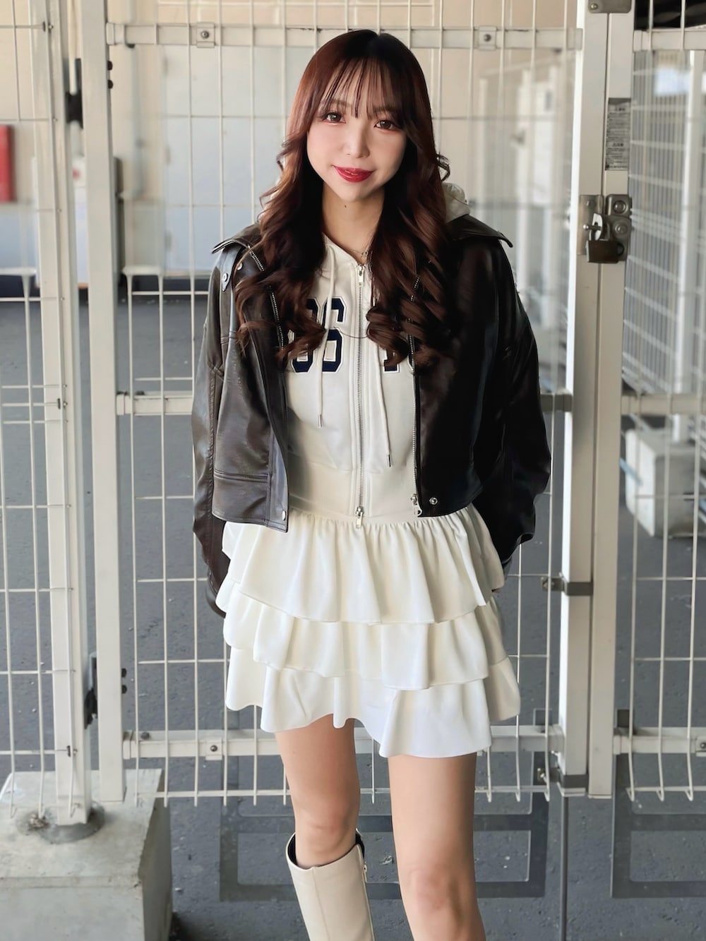 ホワイト系のスウェット、ブラウン系のブルゾン、ホワイト系のスカートを着用したレディースの冬コーディネートの2枚目の写真