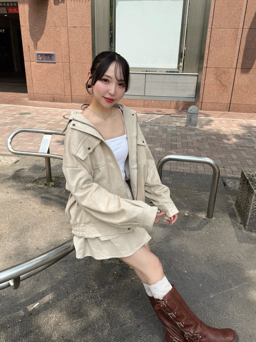 ホワイト系のブルゾン、ホワイト系のキャミソール、ホワイト系のスカートを着用したレディースの秋コーディネートの6枚目の写真